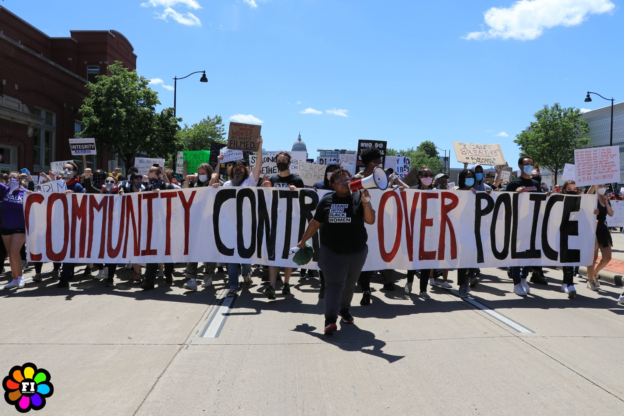 Freedom Inc. at a protest holding a "community control over police" sign