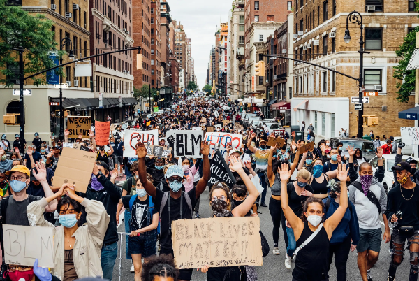 BLM protestors march down a city street.